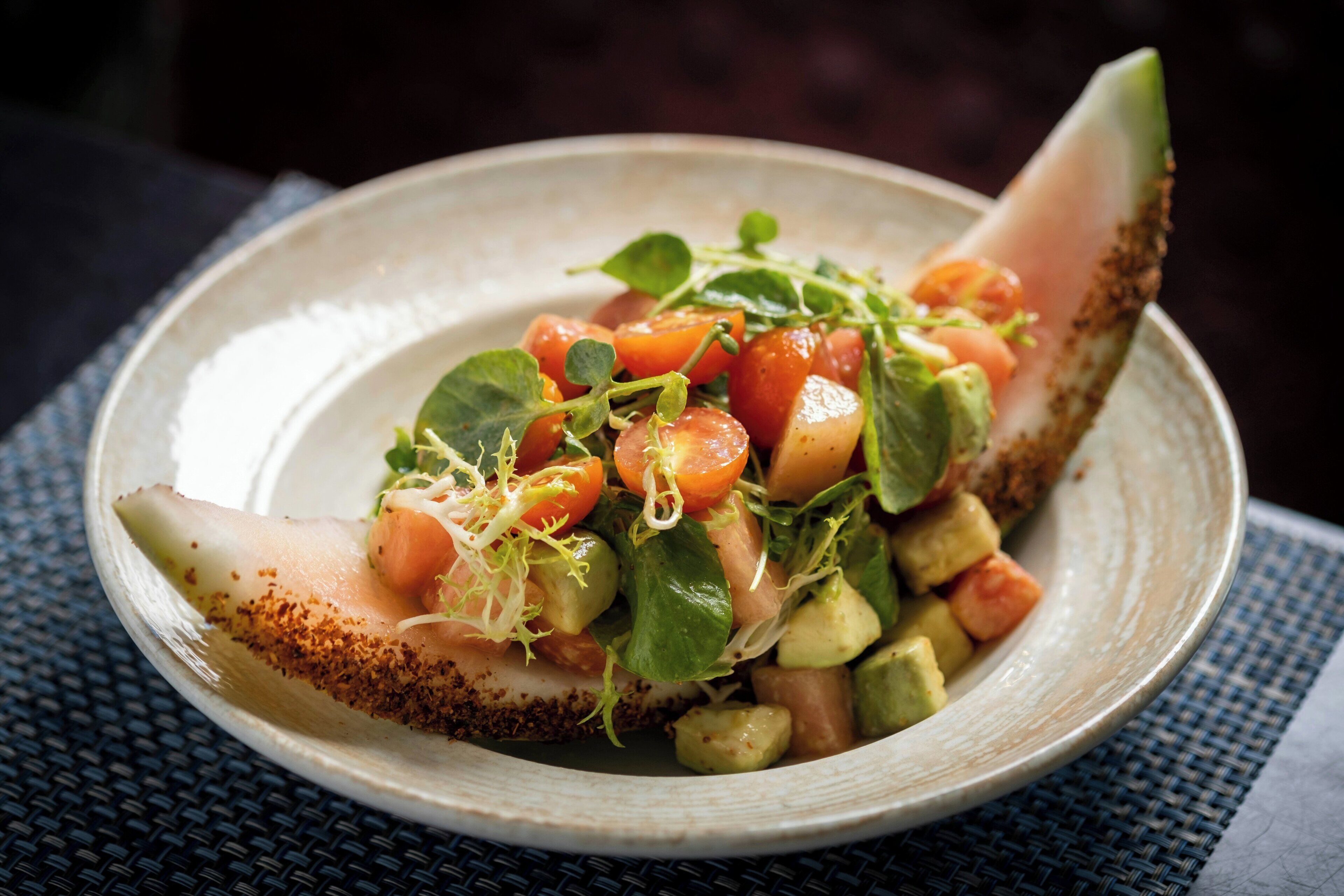Une assiette contenant un plat composé d’un morceau de poisson, de légumes et d’une garniture.