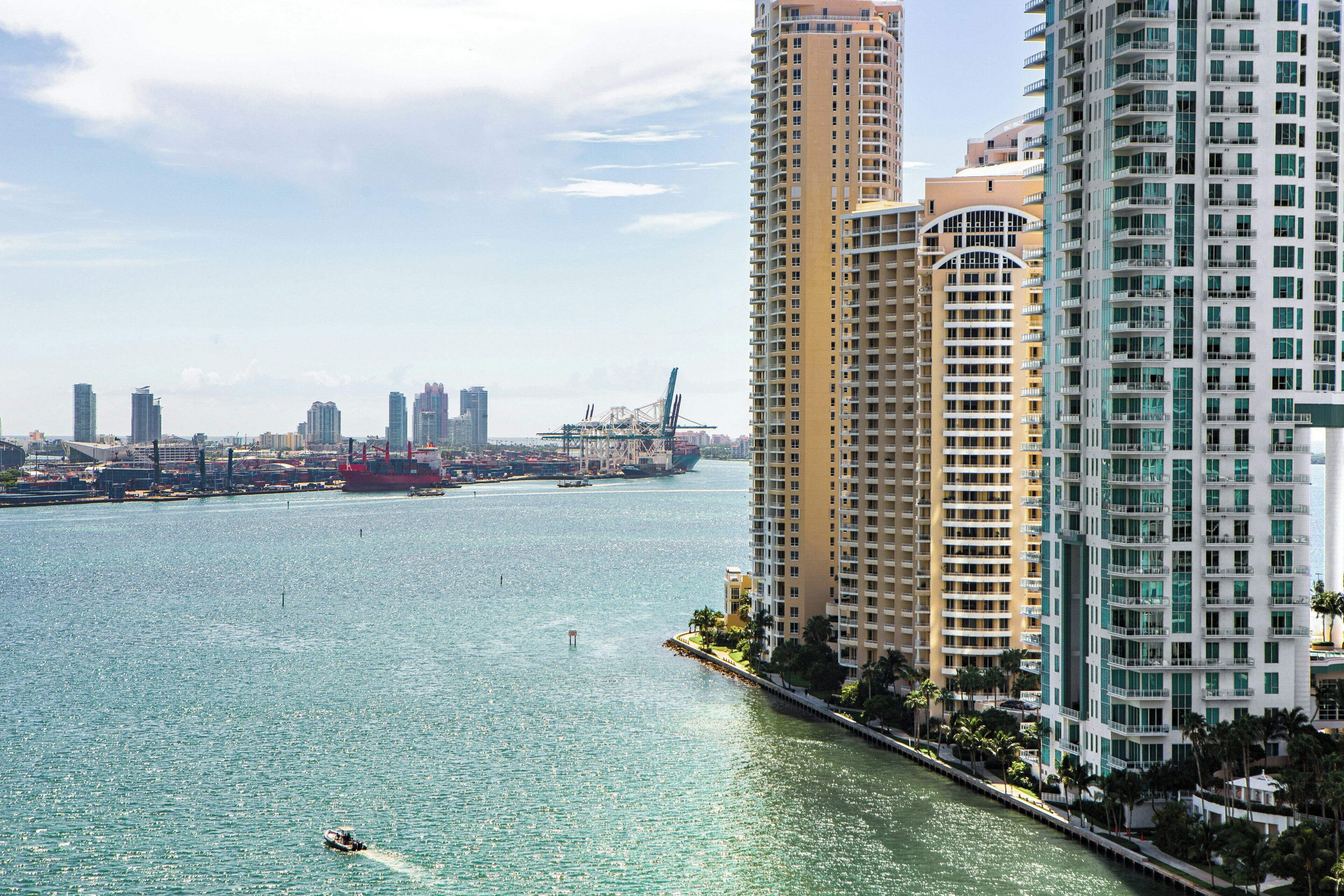 A waterfront property with high-rise buildings, a marina, and a bridge.