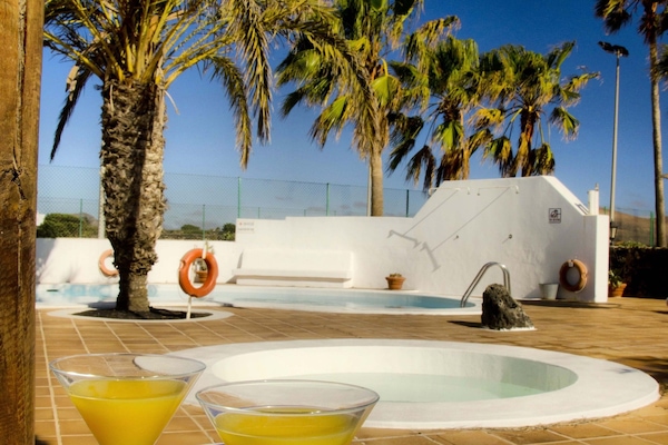 Een buitenzwembad, parasols voor strand/zwembad