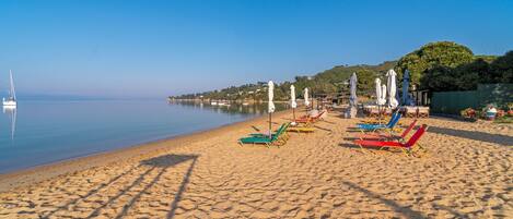 On the beach, white sand, sun loungers, beach umbrellas