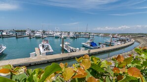 Un port de plaisance où des bateaux sont amarrés aux quais, le tout entouré de verdure.