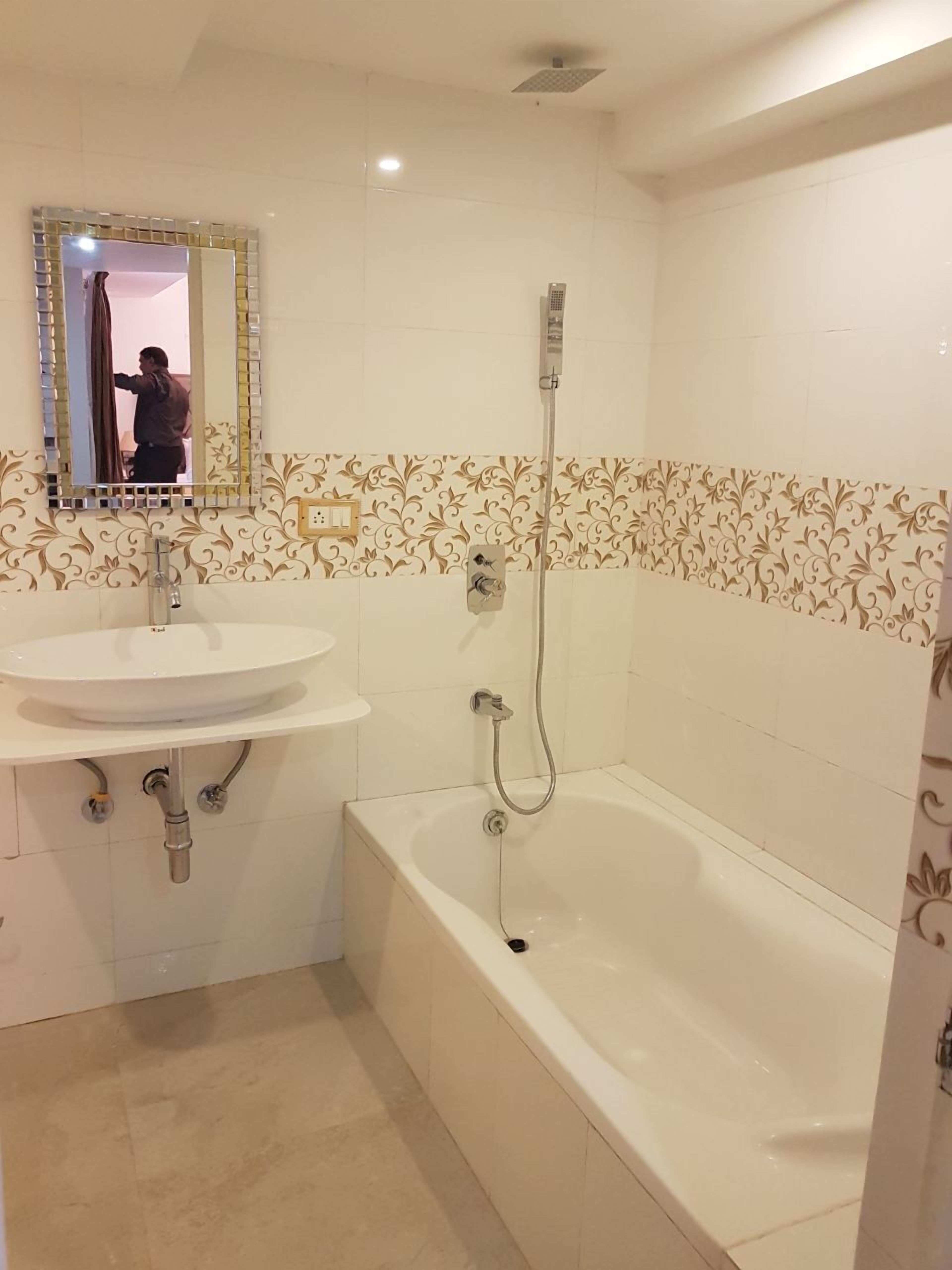 A bathroom with a sink, mirror, shower, and bathtub.