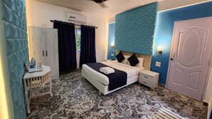 A bedroom with a bed, bedside tables, a wardrobe, and a ceiling fan. - Paradise Village Beach Resort (Calangute)