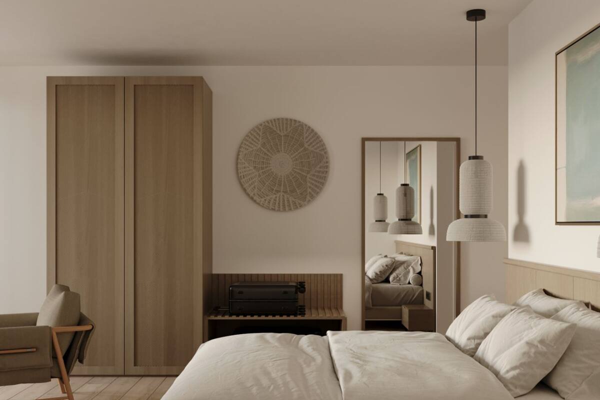 Une chambre à coucher au style minimaliste, avec un grand lit, une armoire en bois, un élément de décoration circulaire fixé au mur et un luminaire suspendu.