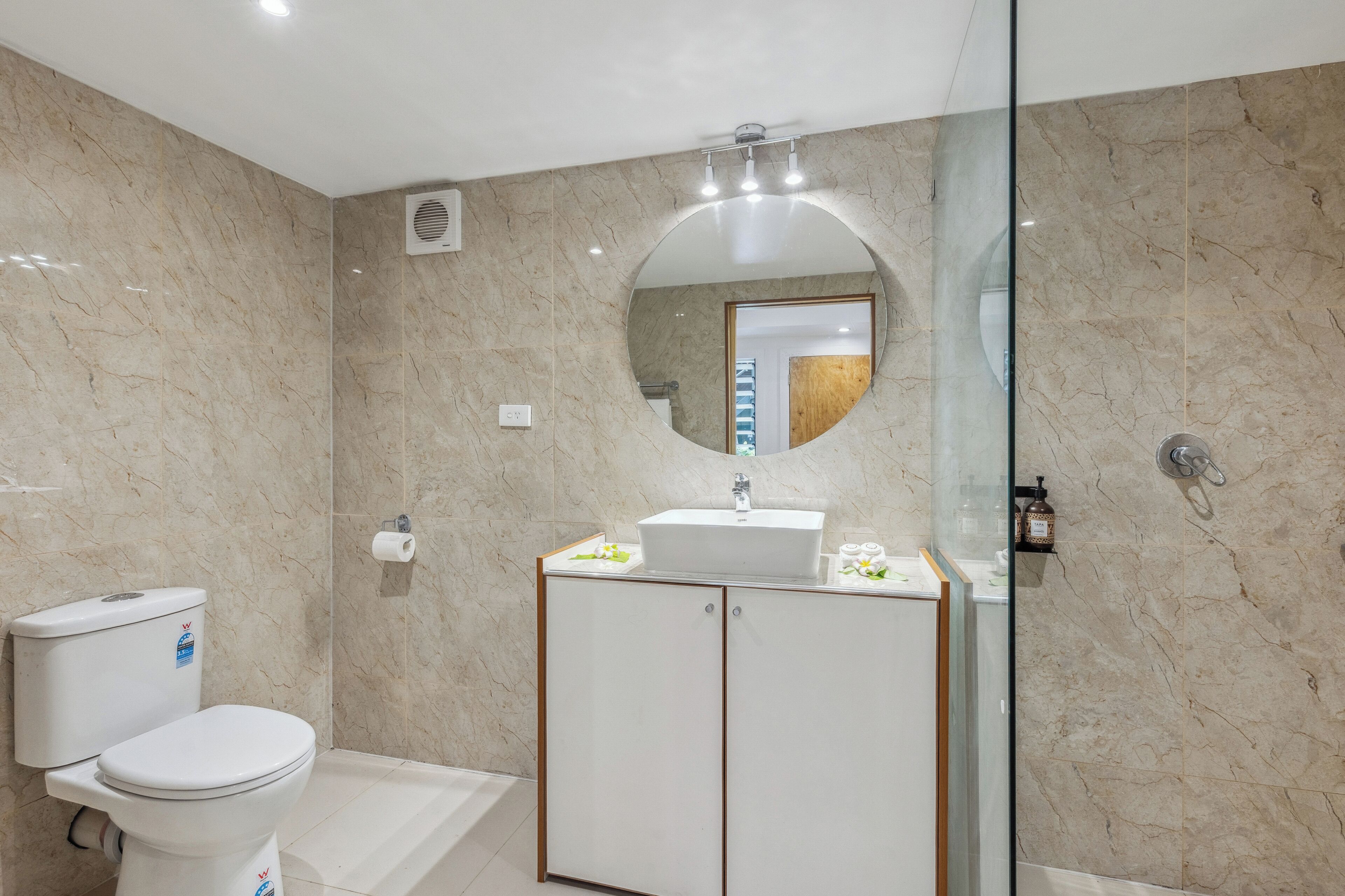 A modern bathroom with a toilet, sink, and shower area.