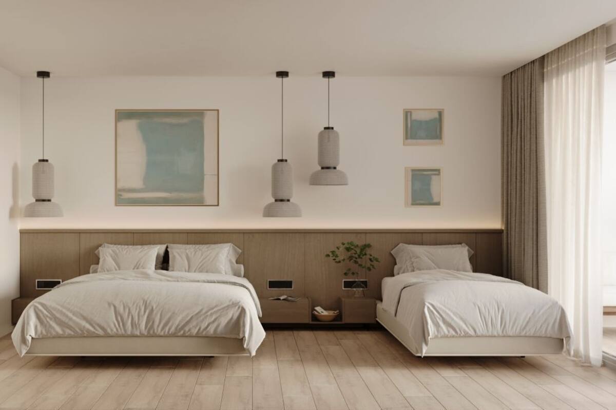 Une chambre moderne avec deux lits, une tête de lit en bois, des lampes suspendues et des œuvres d’art encadrées.