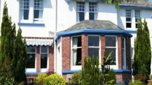 A two-story house with a gabled roof, a bay window, and a brick facade. - Overcombe House (Yelverton)