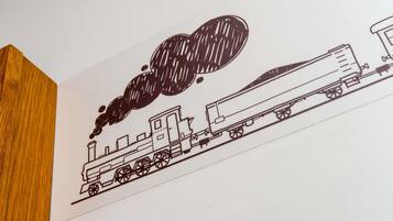 Dibujo en blanco y negro de un tren sobre una pared blanca.