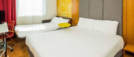 Habitación de hotel con dos camas, un escritorio y una silla.