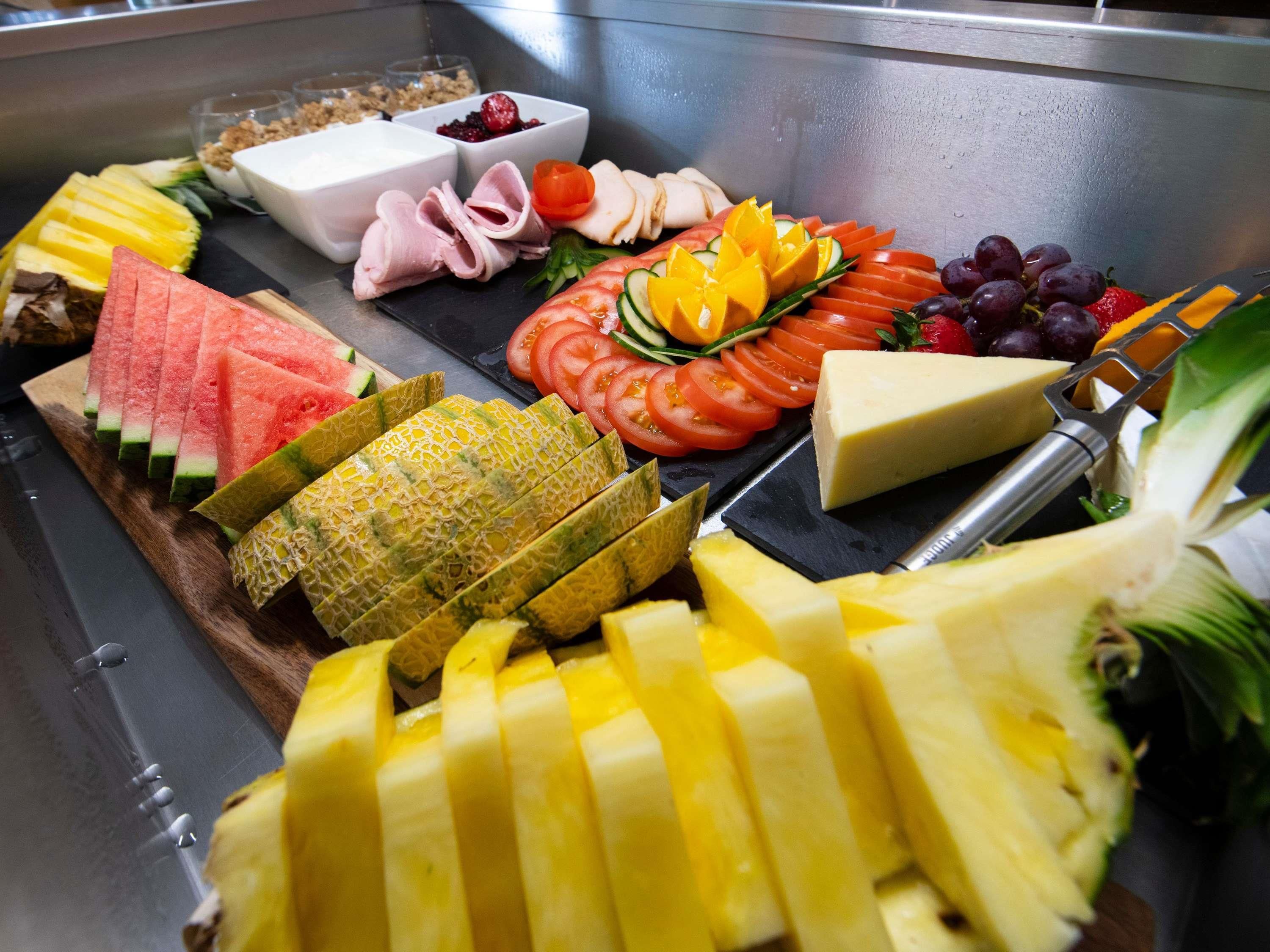 Un buffet proposant une variété de fruits, de légumes et de fromages.