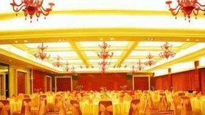 Ein Ballsaal mit Stuhlreihen und einer Bühne.