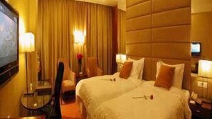 Ein Hotelzimmer mit einem großen Bett, einem Schreibtisch und einem Fernseher.
