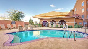 A swimming pool with a tiled deck, a building with a tiled roof, and a signboard. - Residence Inn by Marriott Midland (Midland)