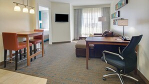 A hotel room with a dining area, a sofa, a desk with a computer, and a TV. - Residence Inn by Marriott Midland (Midland)