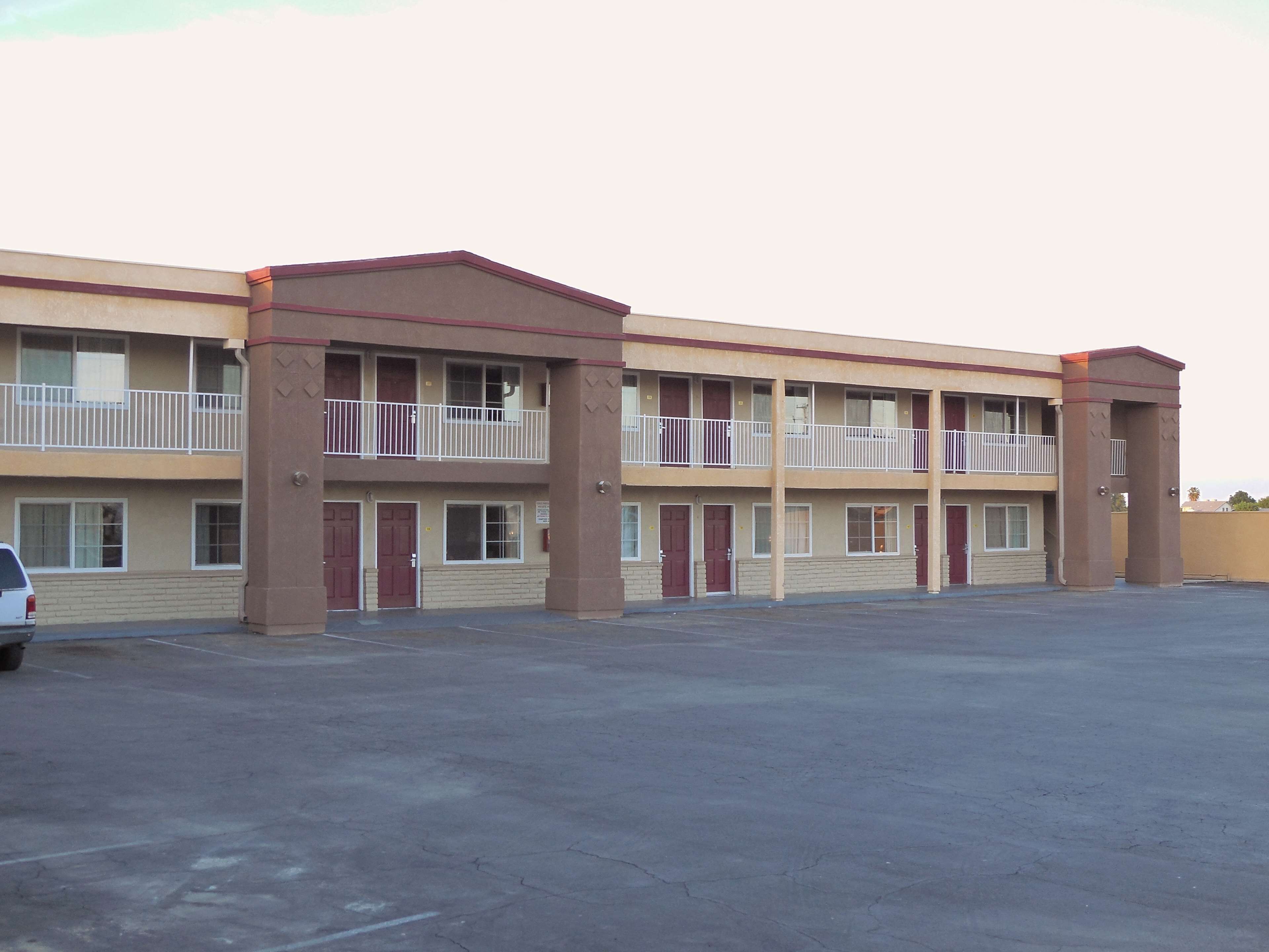 Un motel à plusieurs étages avec un parking situé à l’avant.