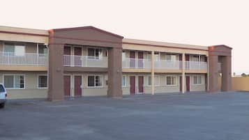 Un motel à plusieurs étages avec un parking situé à l’avant.