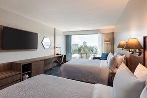 A hotel room with two beds, a desk, a TV, and a large window with a city view. - Holiday Inn Express Quito by IHG (Quito)
