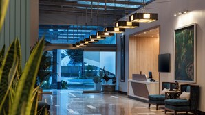 A modern lobby with a reception desk, seating area, and a large window offering a view of the outside. - Holiday Inn Express Quito by IHG (Quito)