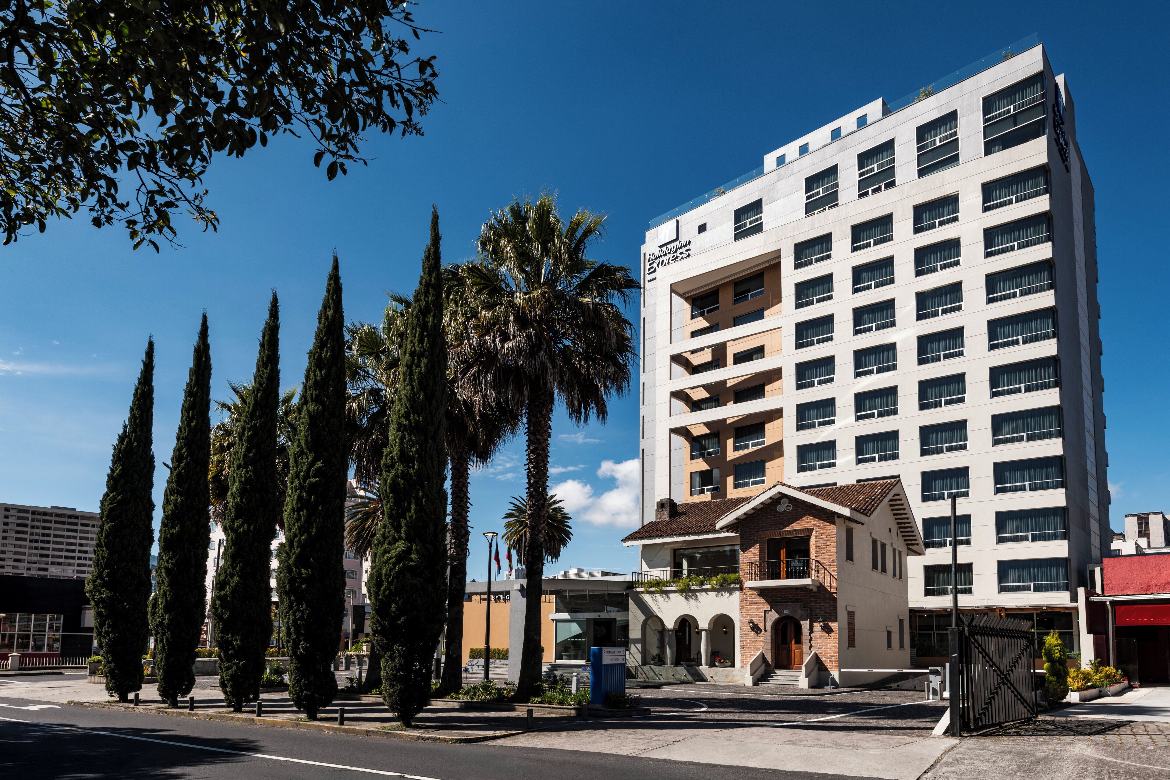 Et moderne hotel med flere etager, med en markant indgang med trapper og et overdækket område.