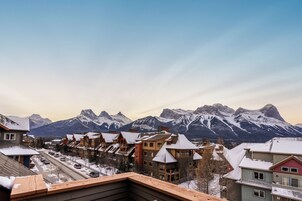 Vista de uma cidade montanhosa com edifícios cobertos de neve e céu limpo.