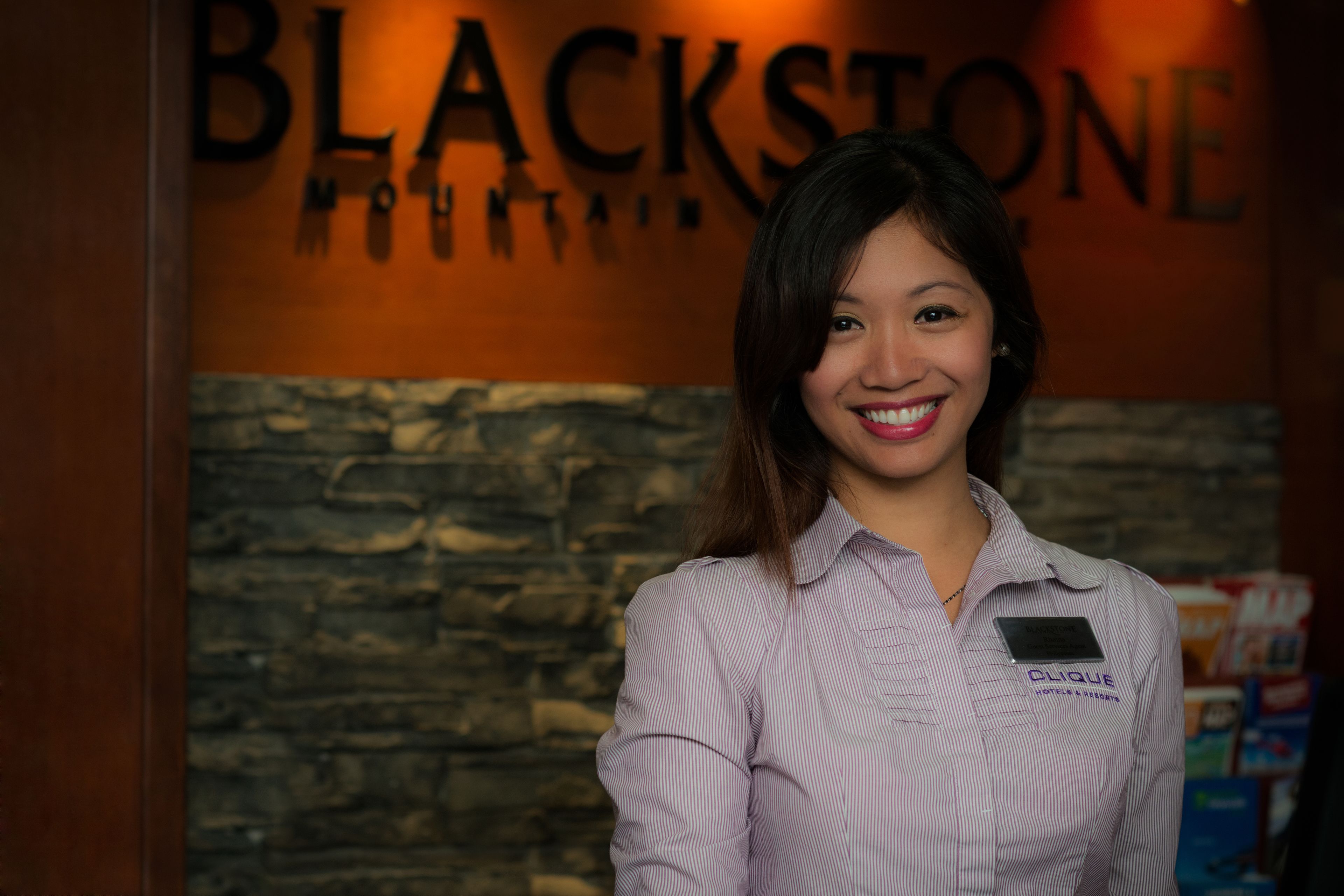 A woman standing in front of a sign that reads "BLACKSTONE FOUNTAIN."