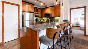 A modern kitchen with wooden cabinets, stainless steel appliances, and a granite countertop.