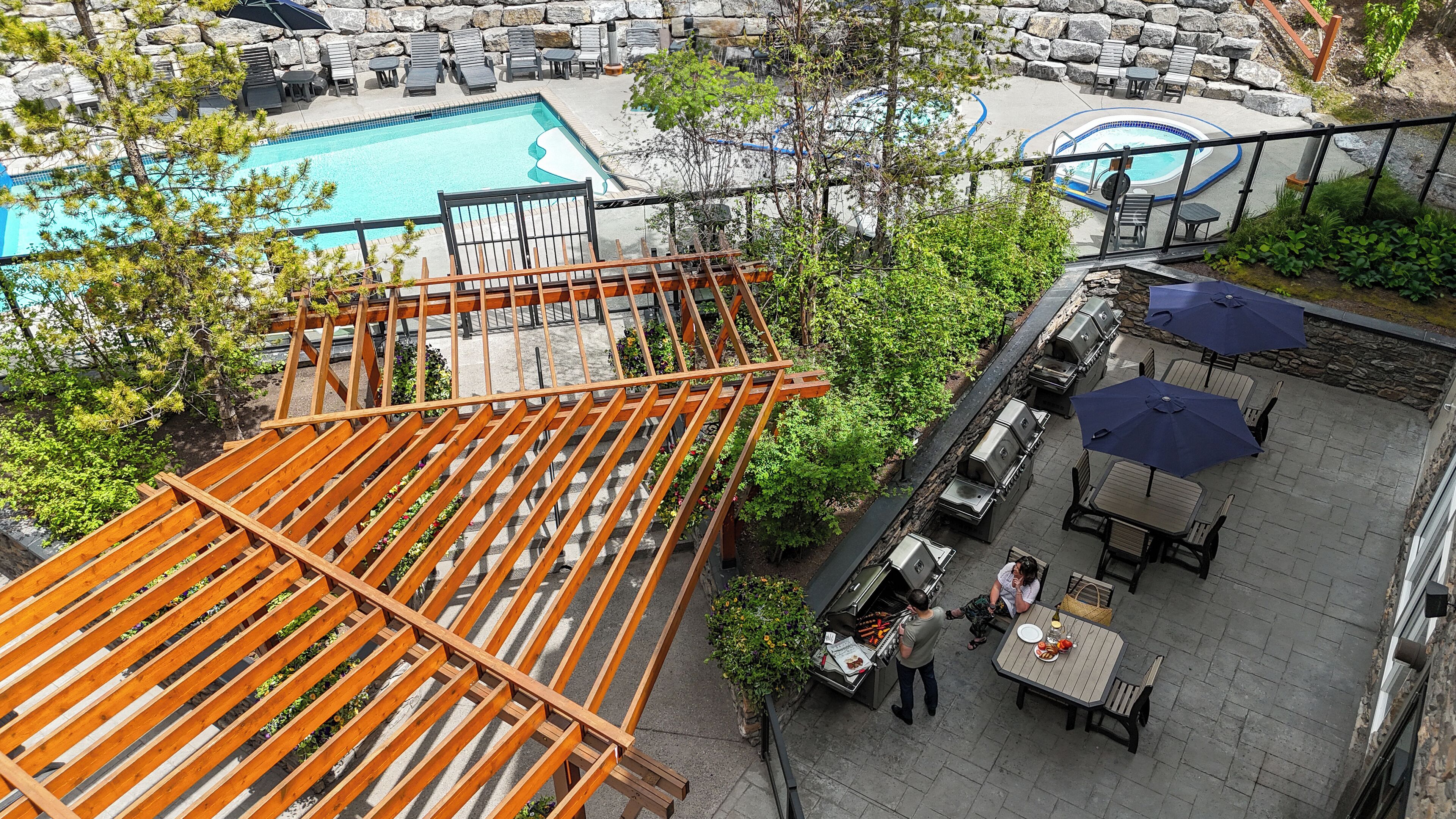 An outdoor pool area with lounge chairs and a barbecue setup.