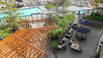 Zona de piscina al aire libre con sillones de descanso y una zona de barbacoa.