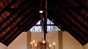 A spacious living area with a high ceiling, a chandelier, and a large window with curtains. - Entabeni Mountain Lodges (Mookgopong)