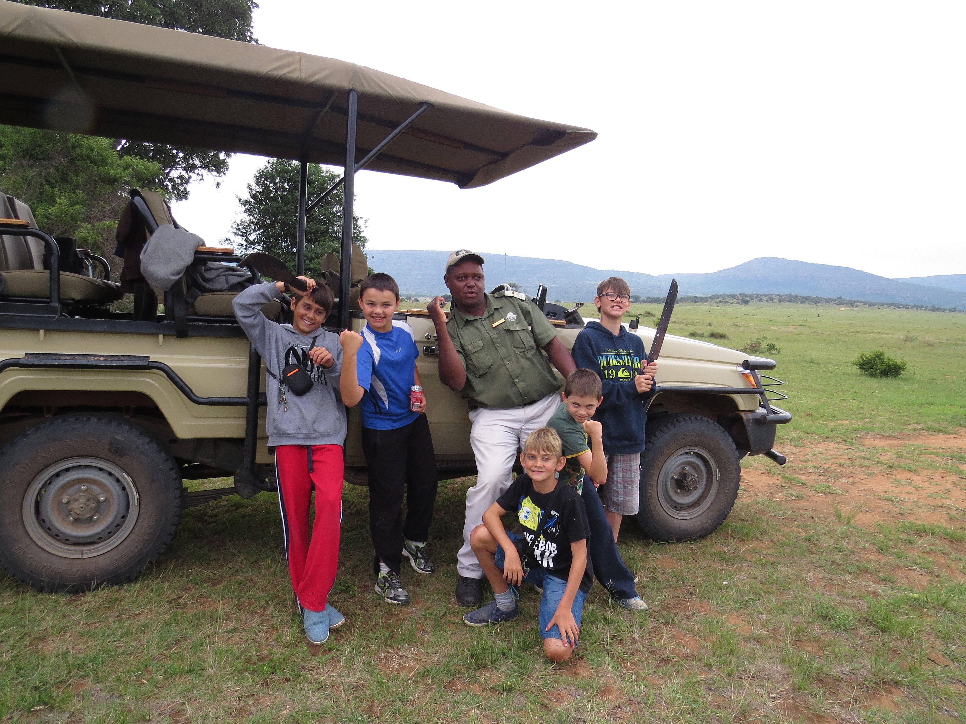 Un groupe de personnes posant devant un véhicule de safari équipé d’un toit.