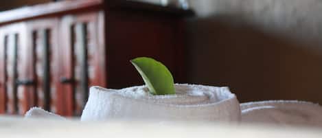 A towel with a green leaf on it, placed on a surface with a blurred background.