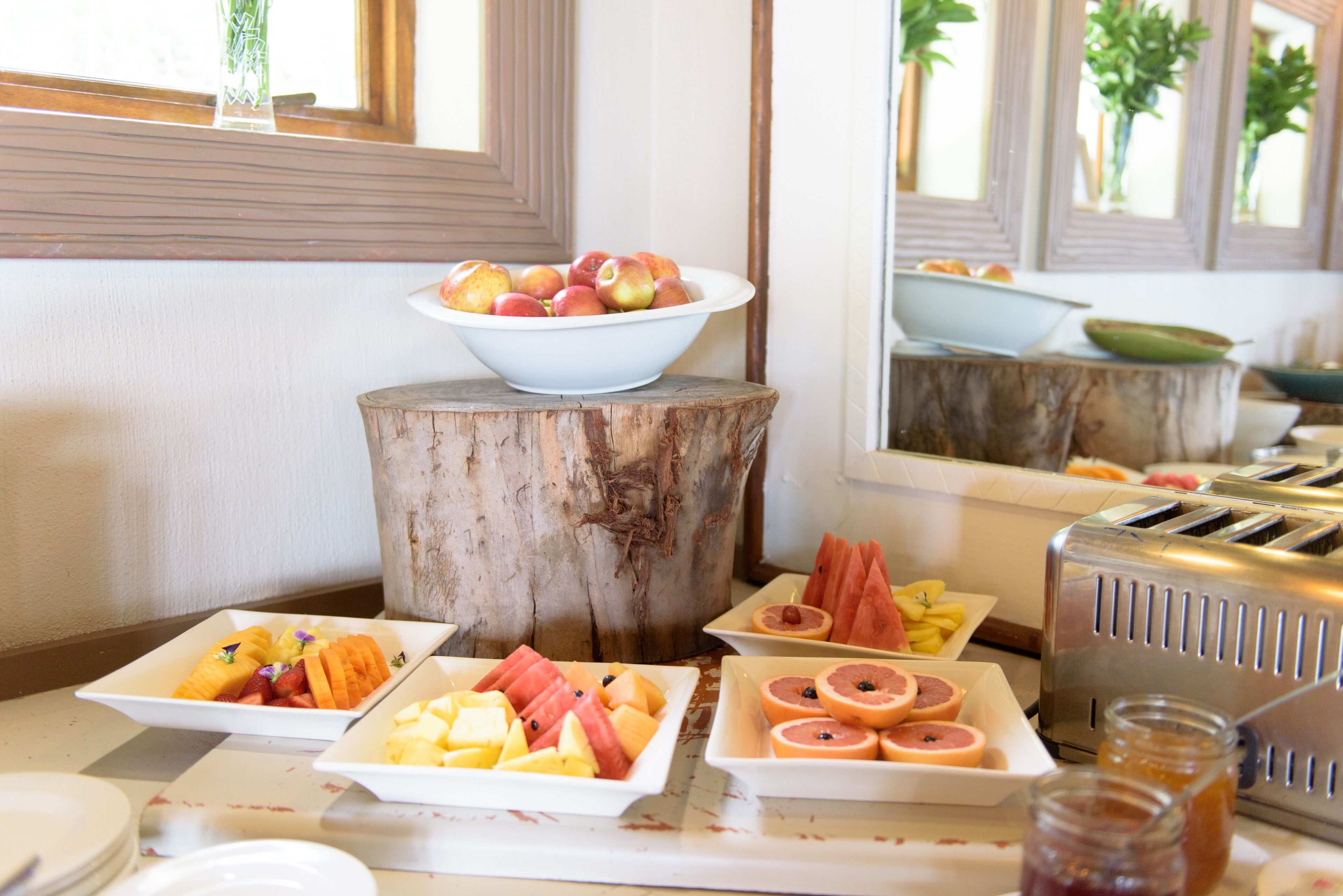 Un bufé de desayuno con diversas frutas y un tostador.