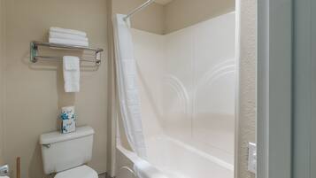 A bathroom with a toilet, a shower with a curtain, and a shelf with towels.