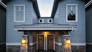 A two-story house with a front porch, stone pillars, and a number '3' on the left side. - Pacific Reef Hotel & Light Show (Gold Beach)