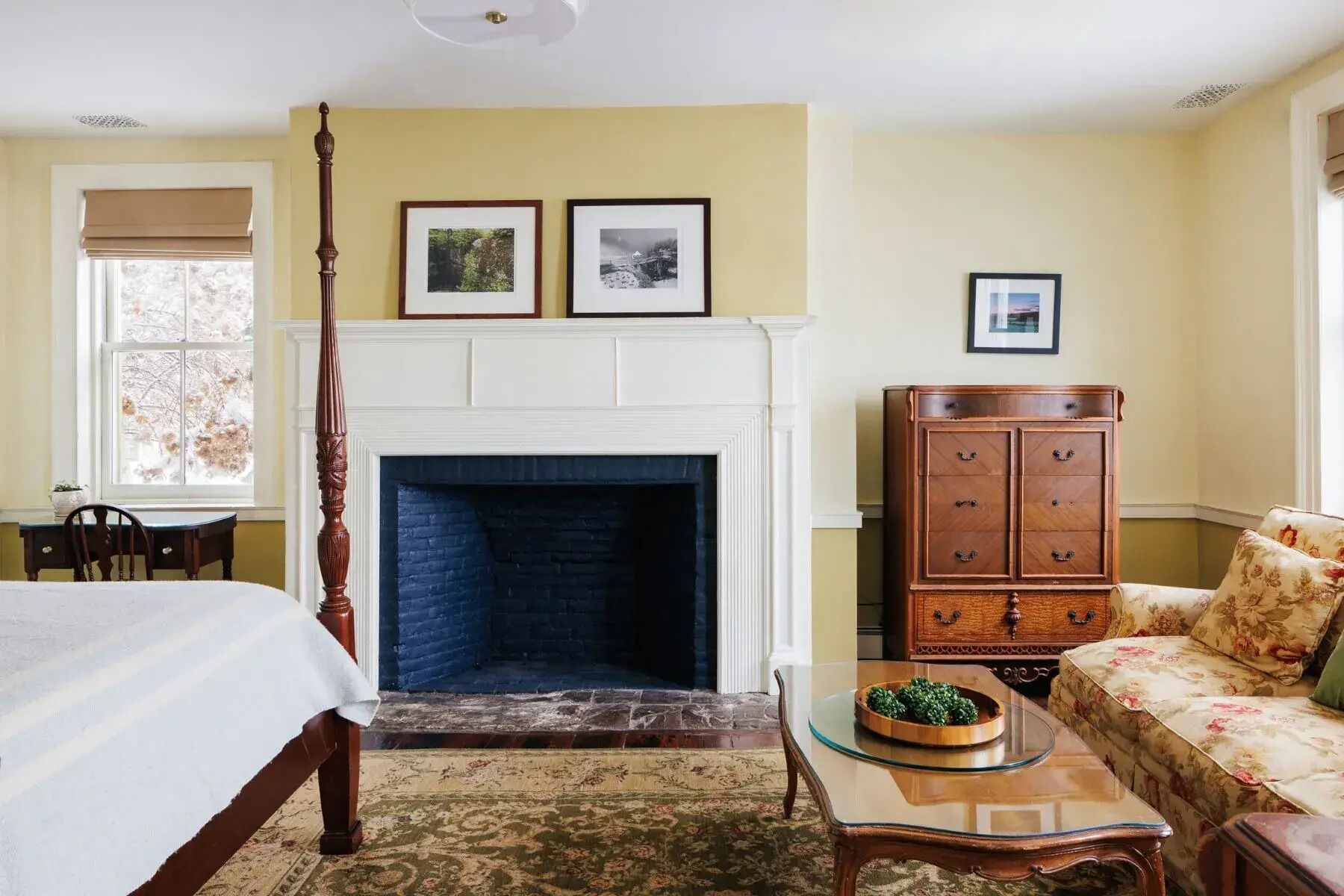 A room with a fireplace, a bed, a wooden cabinet, and a sofa.
