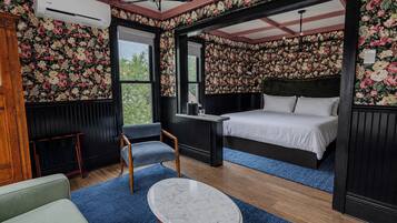 Ein Schlafzimmer mit Bett, Stuhl, Tisch und Fenster.