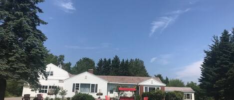A two-story white house with a red porch and a garage.