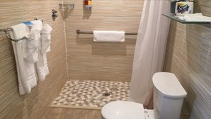 A bathroom with a shower, toilet, and towel rack.