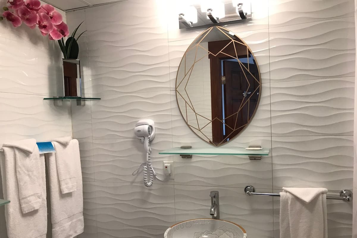 Chambre, 1 très grand lit | Salle de bain | Ensemble baignoire-douche, douche cascade