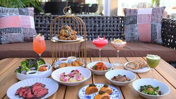 A table set with various dishes, drinks, and a decorative birdcage centerpiece.