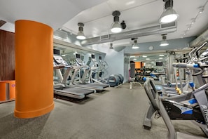 A gym with treadmills, elliptical machines, and weight equipment.