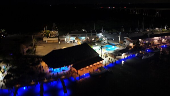 A nighttime view of a waterfront area with illuminated structures and boats.