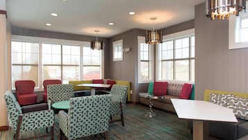 A modern lounge area with seating arrangements, including chairs and sofas, and a small table.