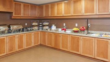 A kitchen with wooden cabinets, granite countertops, and various appliances including a coffee maker and a toaster.