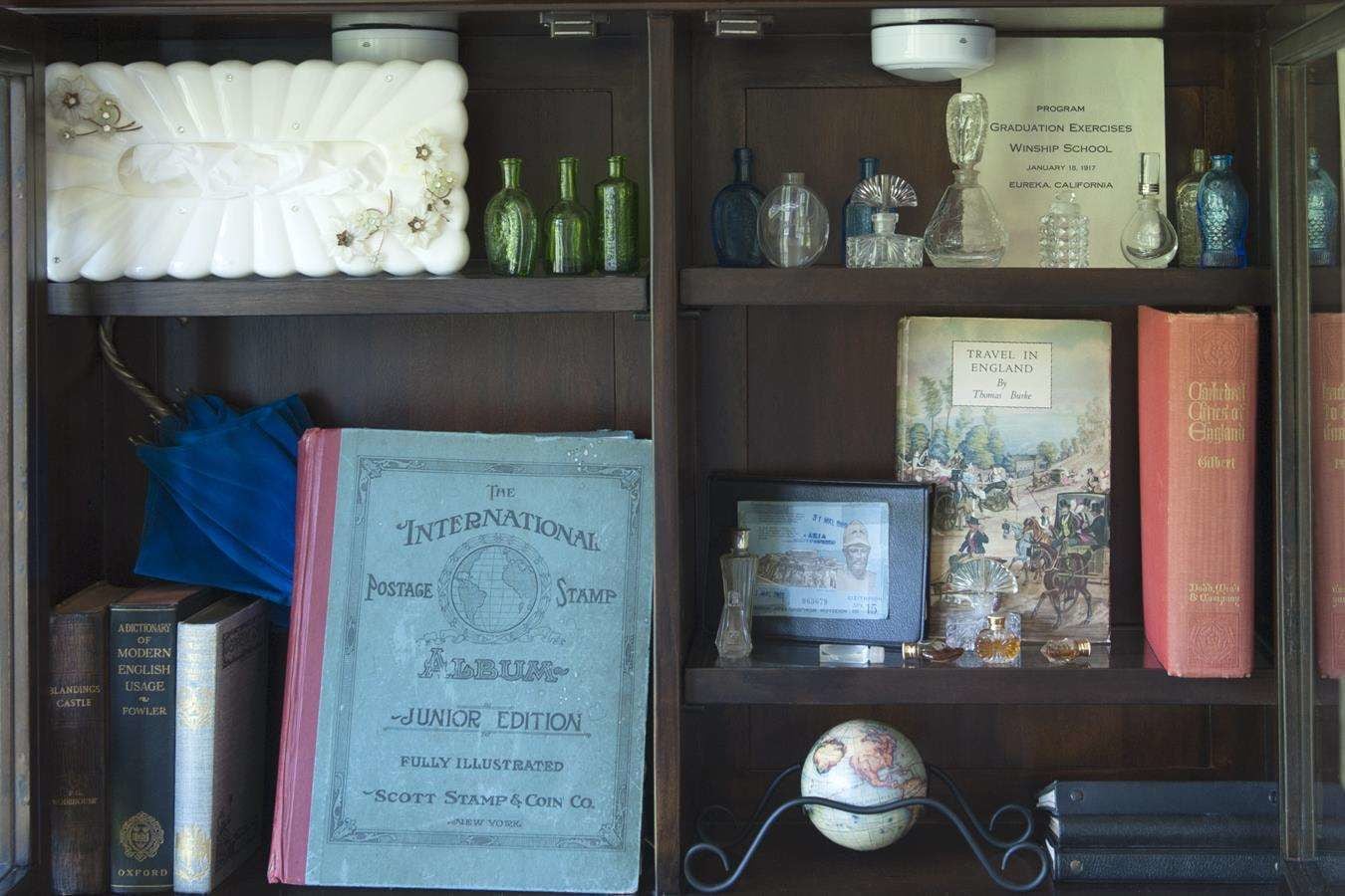 A display of vintage books, globes, and decorative items on shelves.