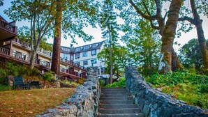 A stone staircase leading up to a building with multiple balconies and a view of trees.