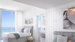 A modern hotel room with a bed, a sofa, a coffee table, and a view of the ocean. - Grand Beach Hotel (Miami Beach)
