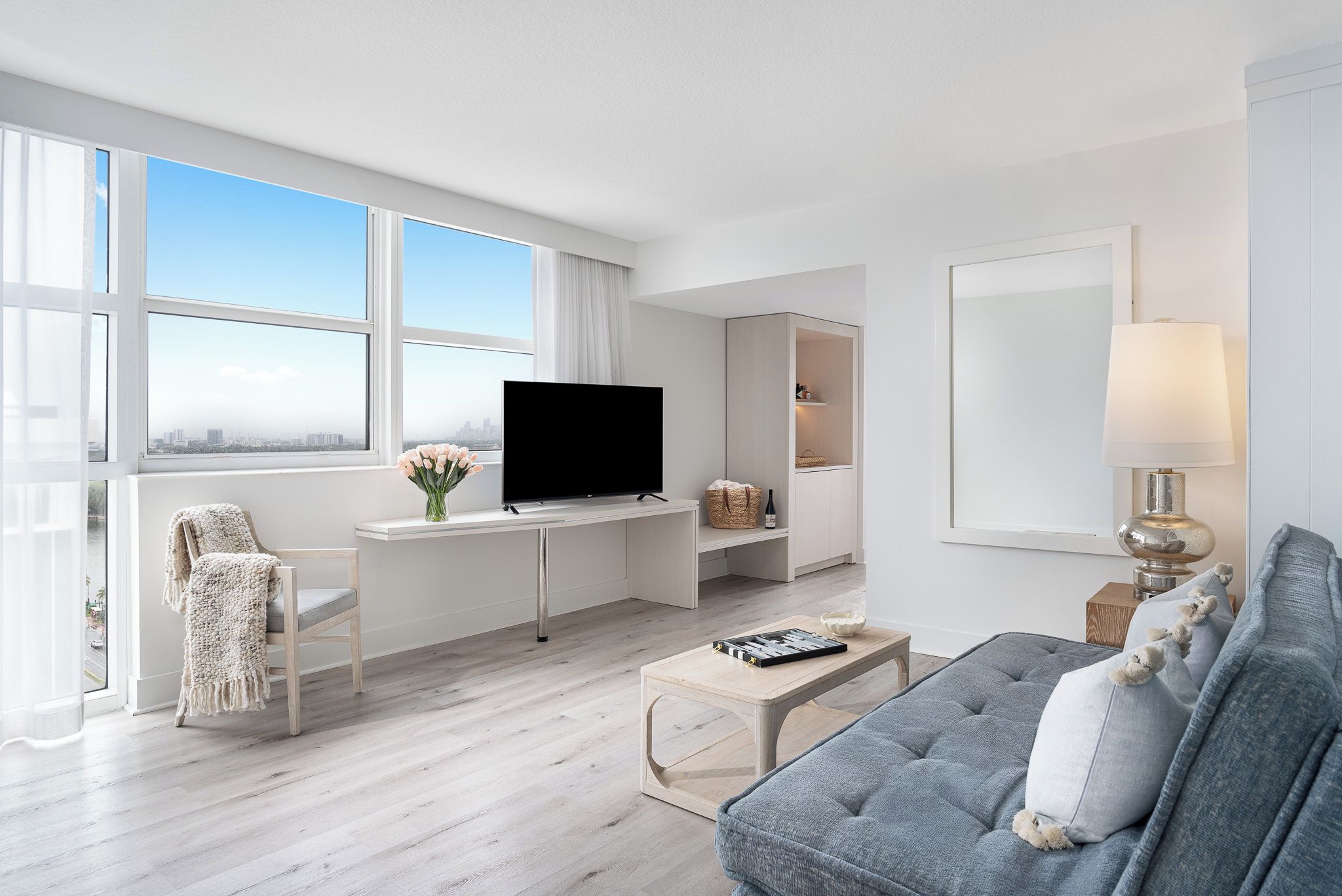 Ein modernes Wohnzimmer mit Flachbildfernseher, einer Couch, einem Couchtisch und einem Sessel.