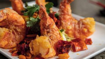 A plate of fried seafood with vegetables and herbs.