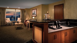 Een hotelkamer met uitzicht op de stad, een bar en een eetgedeelte.